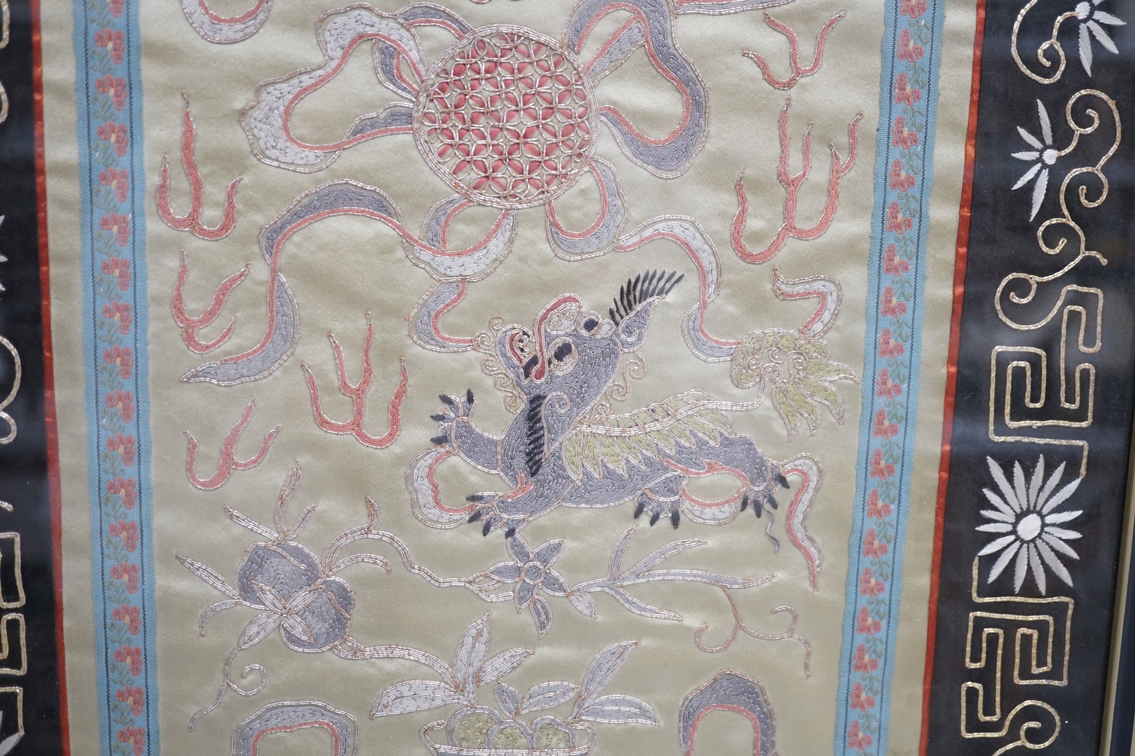 A framed Chinese dragon silk panel. 64 x 34cm